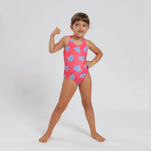 Load image into Gallery viewer, Breazies Girls one piece swimsuit with blue turtles on a coral background - shown on girl with her thumb up