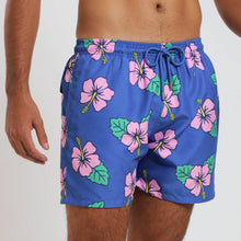 Load image into Gallery viewer, Breazies men swim shorts with pink hibiscus flower on a blue background - front view shown close up on a model