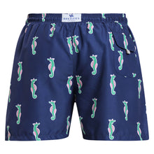 Load image into Gallery viewer, Breazies men swim shorts with green and pink sea horses on a navy background - back view