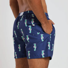 Load image into Gallery viewer, Breazies men swim shorts with green and pink sea horses on a navy background - side view shown on model