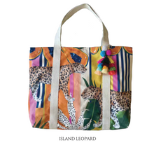 Load image into Gallery viewer, Example of a durable beach bag by Natural Selection features a vibrant design with two leopards and multicloured stripes. Decorative tassels in pink, blue, yellow, and green adorn the strap.  It has a waterproof lining for protection.