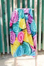 Load image into Gallery viewer, Bobums UAE Microfibre beach towel with Sorbet Snails design on ladder in front of wooden panelled wall at La Mer