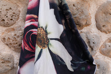 Load image into Gallery viewer, Close up of Bobums UAE Microfibre beach towel with Vintage Rose design on coral wall