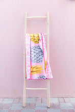 Load image into Gallery viewer, Bobums UAE Microfibre beach towel with Wild Pines design on ladder in front of pink wall at Tania's Teahouse