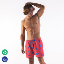 Load image into Gallery viewer, Man wearing starfish swim shorts, adults  - Blue starfish design on coral background