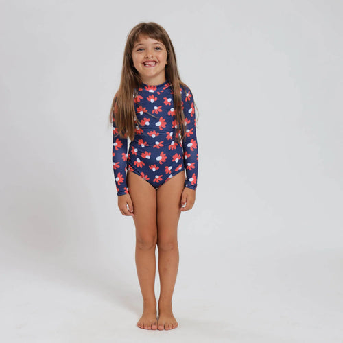 Breazies girls long sleeve swimsuit with red and white daisies on a navy background - front view shown on young girl