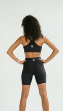 Load image into Gallery viewer, Person wearing a black sports bra and Koko Active gym or running shorts set on a white background.
