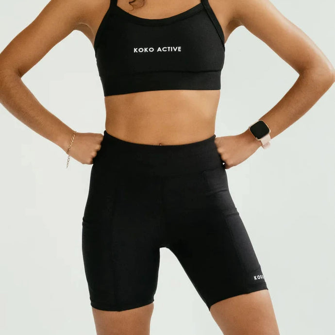 Woman wearing a black sports bra and Koko Active shorts with 'Xero Active' branding on a white background.