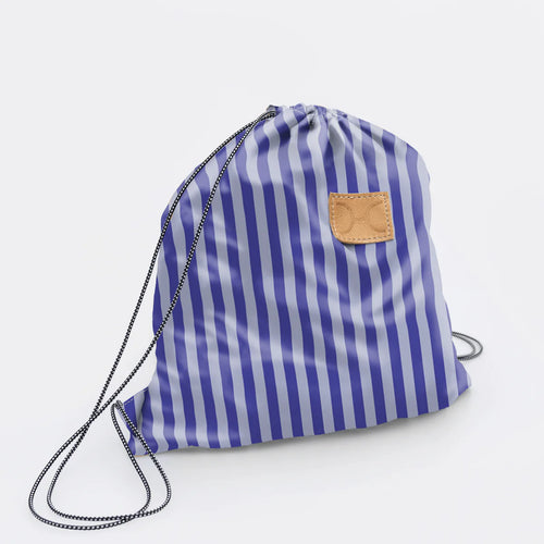 Thandana Blue and white striped drawstring bag with a leather logo on a light grey background