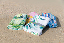 Load image into Gallery viewer, Folded Bobums UAE Microfibre beach towels with elastic band on beach sand
