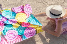 Load image into Gallery viewer, Woman with hat laying down her Bobums UAE Microfibre beach towel with Sorbet Snails design
