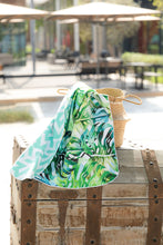 Load image into Gallery viewer, Bobums UAE Microfibre beach towel with Delicious Window design on double sided printed towel in basket at La Mer
