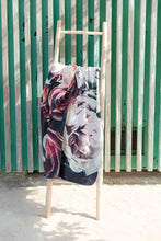 Load image into Gallery viewer, Bobums UAE Microfibre beach towel with Vintage Rose design on ladder against wooden panelled wall at La Mer
