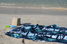Load image into Gallery viewer, Bobums UAE Microfibre beach towel with Blue Palms Kids design on sand with sandcastle at Black Palace Beach
