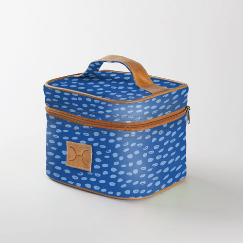 A blue Thandana mini deck insulated cooler bag with a geometric seed pattern, featuring a brown leather handle and YKK zippers. Laminated fabric for easy cleaning.