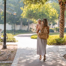 Load image into Gallery viewer, Mother with child in  the park, wearing a stylish Thandana backpack-style baby nappy bag made from genuine leather
